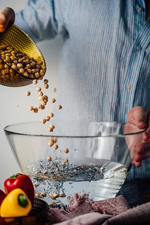 man washing chickpeas for a healthy gut-loving recipe