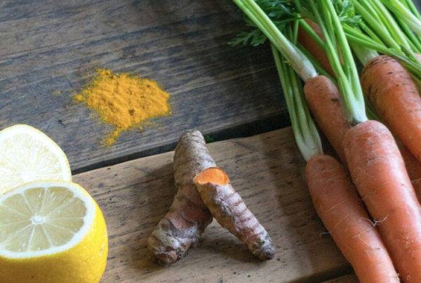 fresh juice ingredients including ginger lemon turmeric and carrots