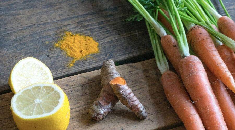 fresh juice ingredients including ginger lemon turmeric and carrots